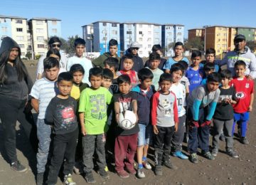 Jean Fuentes Astorga junto a niños y niñas de la Escuela de Fútbol Juventud Artificio.