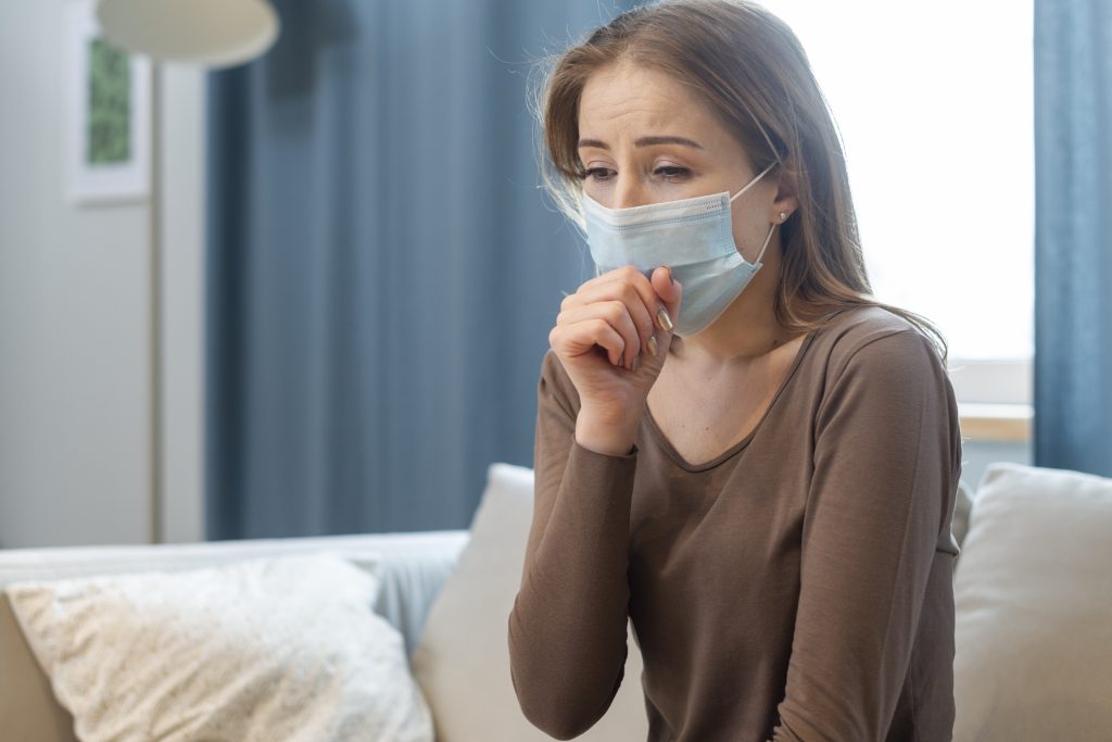 virus de invierno mujer con mascarilla tosiendo